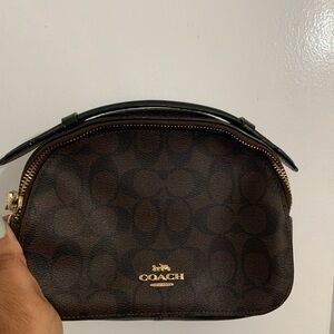 Fairly new Coach brand purse. Brown leather Coach detailed lettering with strap.